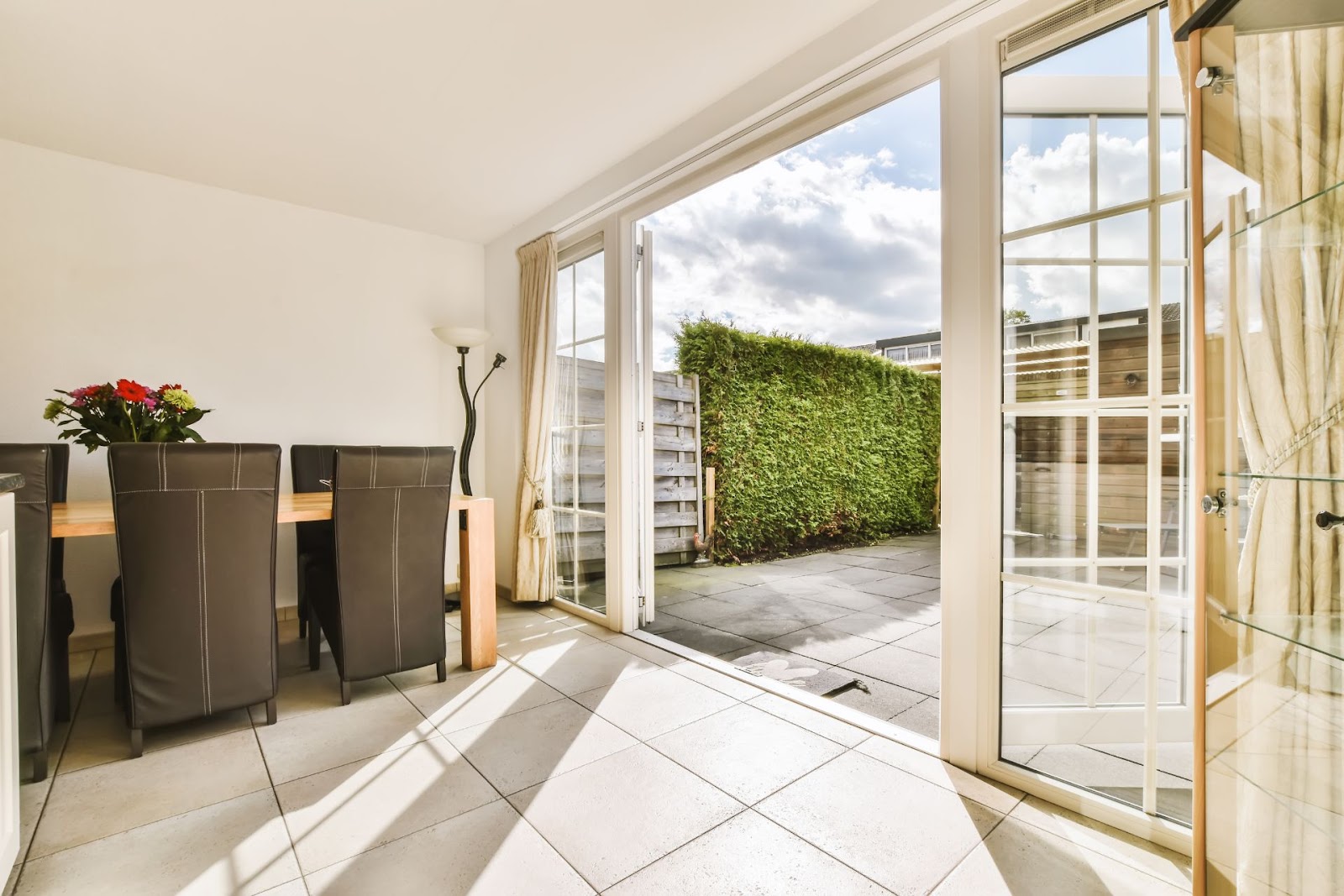 Open patio doors leading to a small outdoor garden
