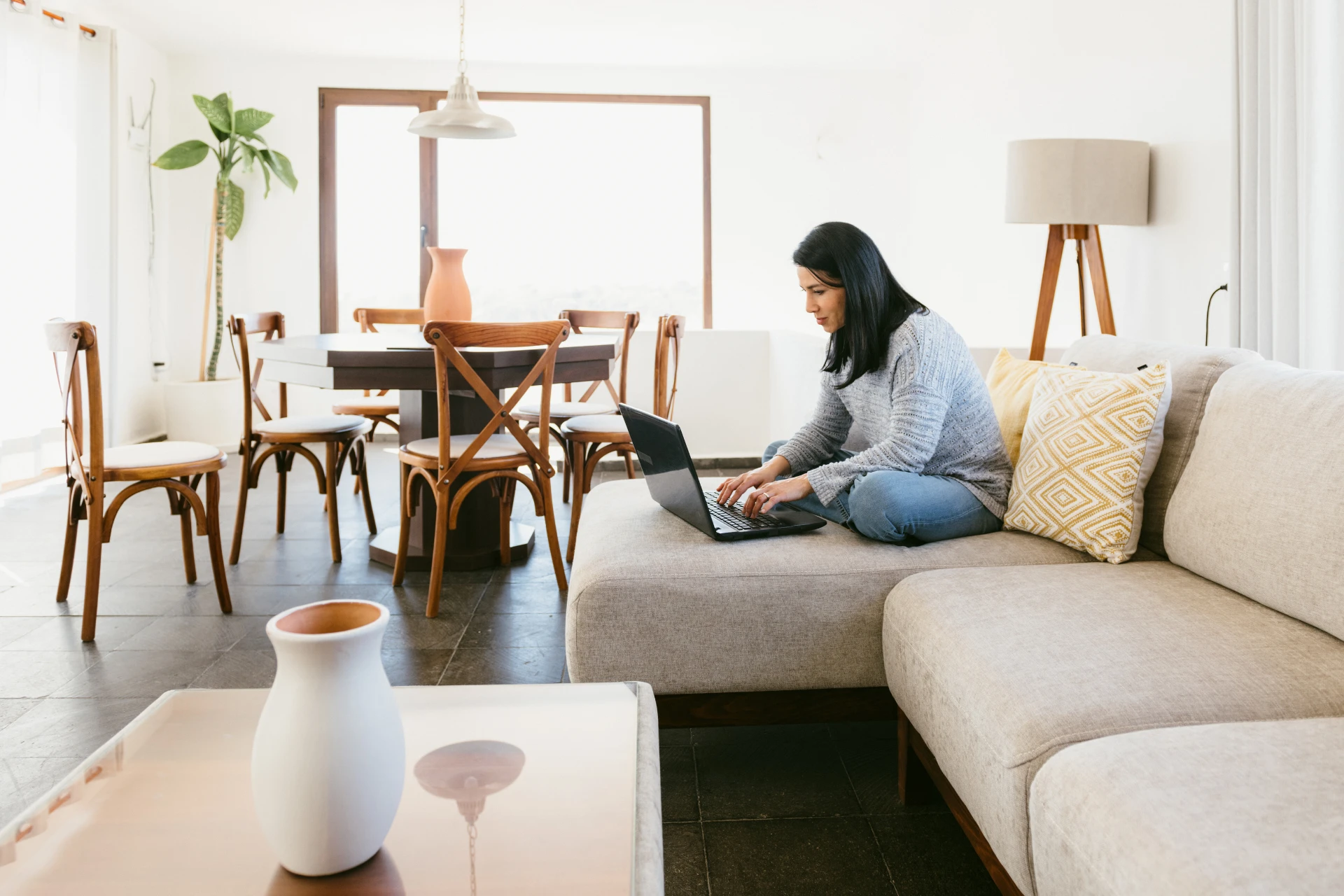 A tenant sitting on the couch, working on her laptop