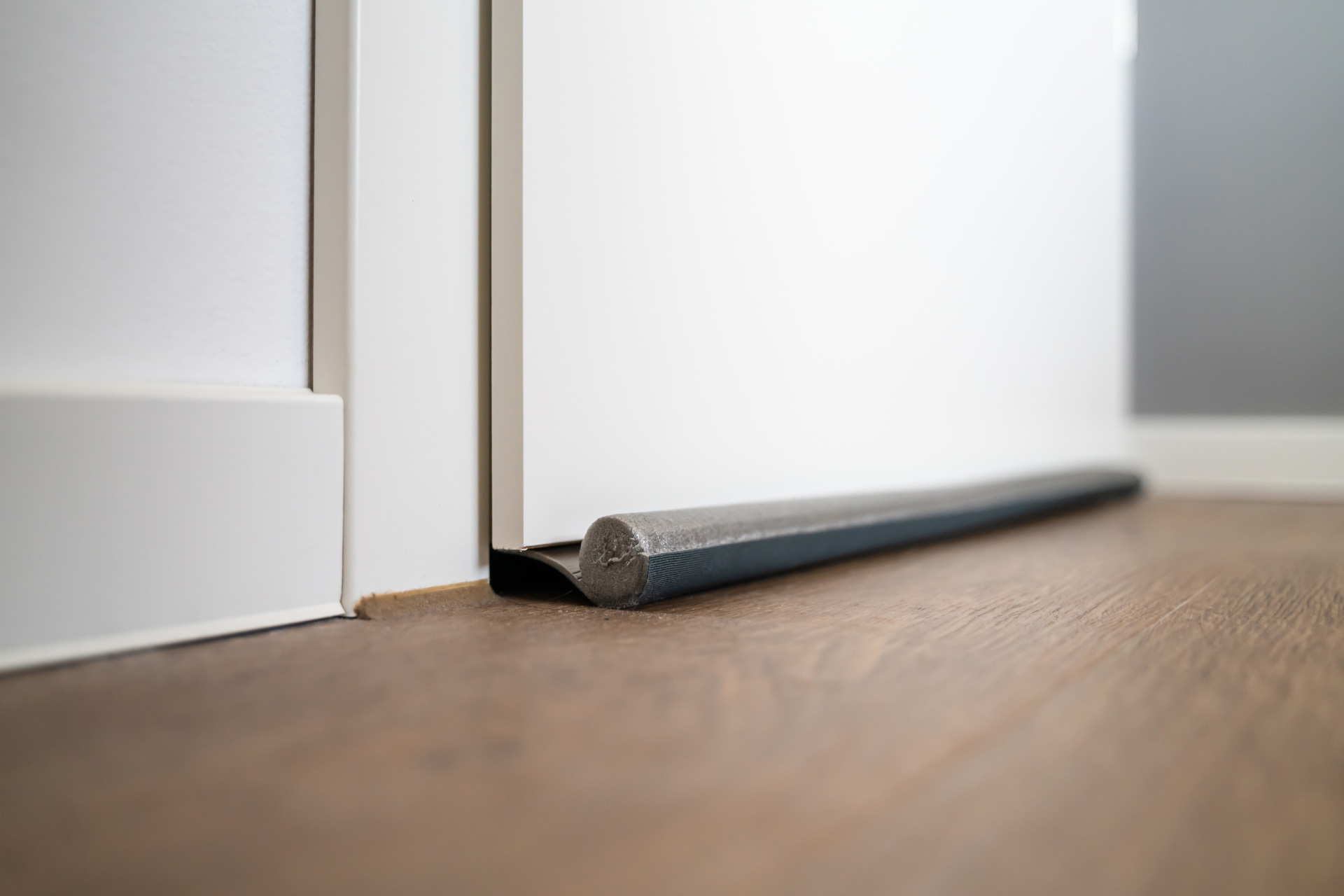 A white door with a door excluder to prevent door draft