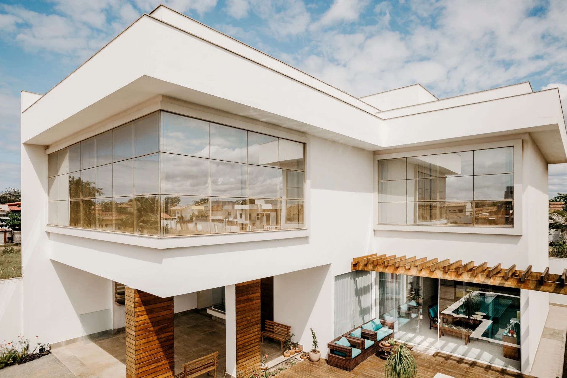 Stylish contemporary house exterior with large windows and wooden details under a blue sky
