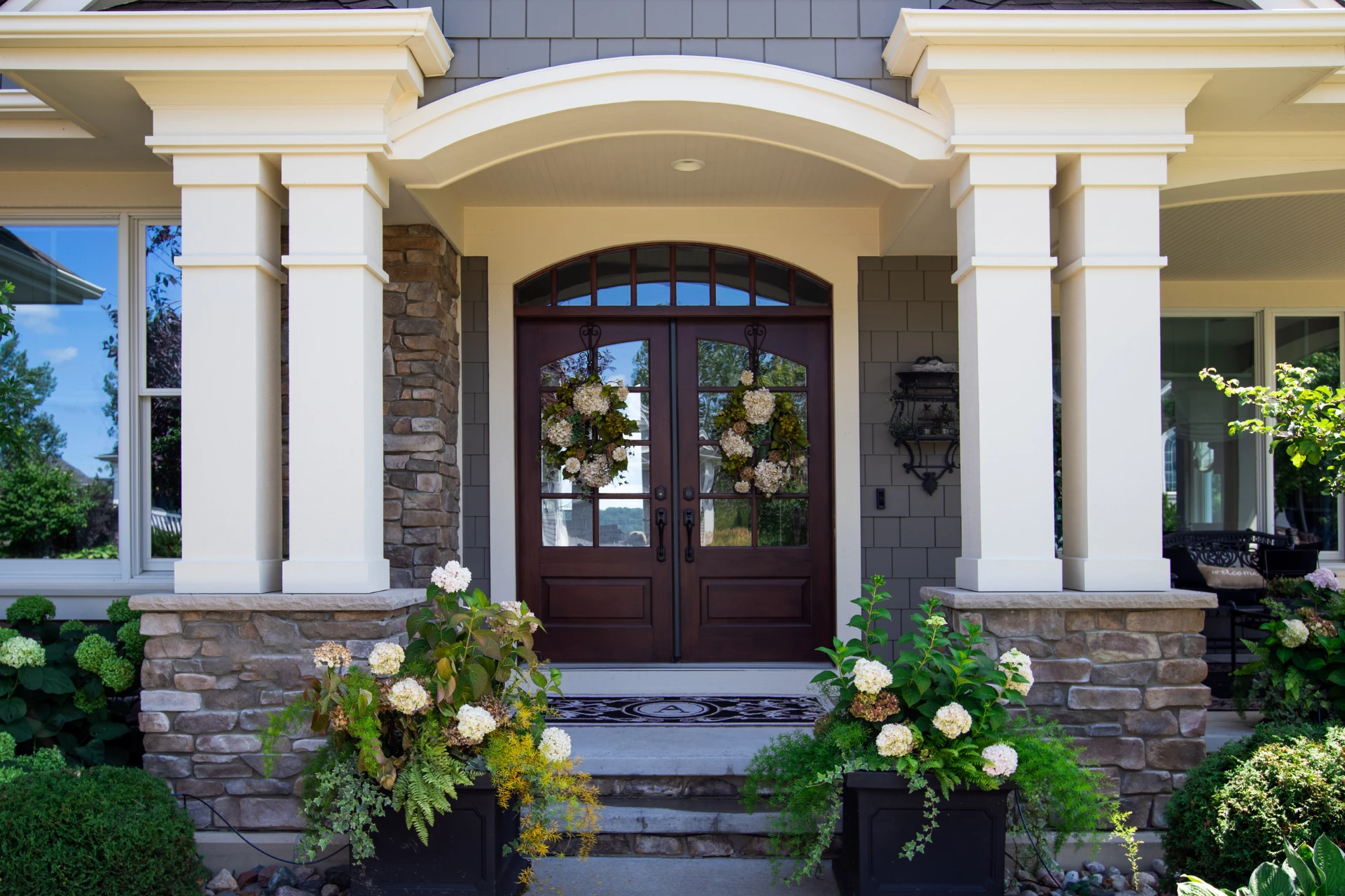 A home entryway, featuring custom French doors, composed of wood and glass.