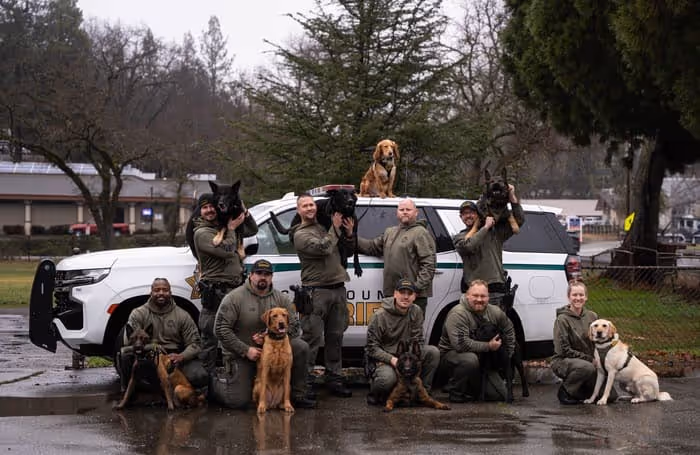 K9 officers with K9 in front of car