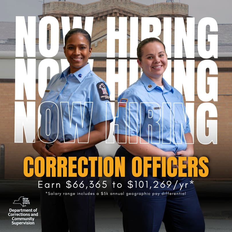 Two smiling correction officers in blue uniforms standing in front of a brick building, with text overlay stating 'Now Hiring Correction Officers, Earn $66,365 to $101,269/yr,' and New York State Department of Corrections and Community Supervision logo.