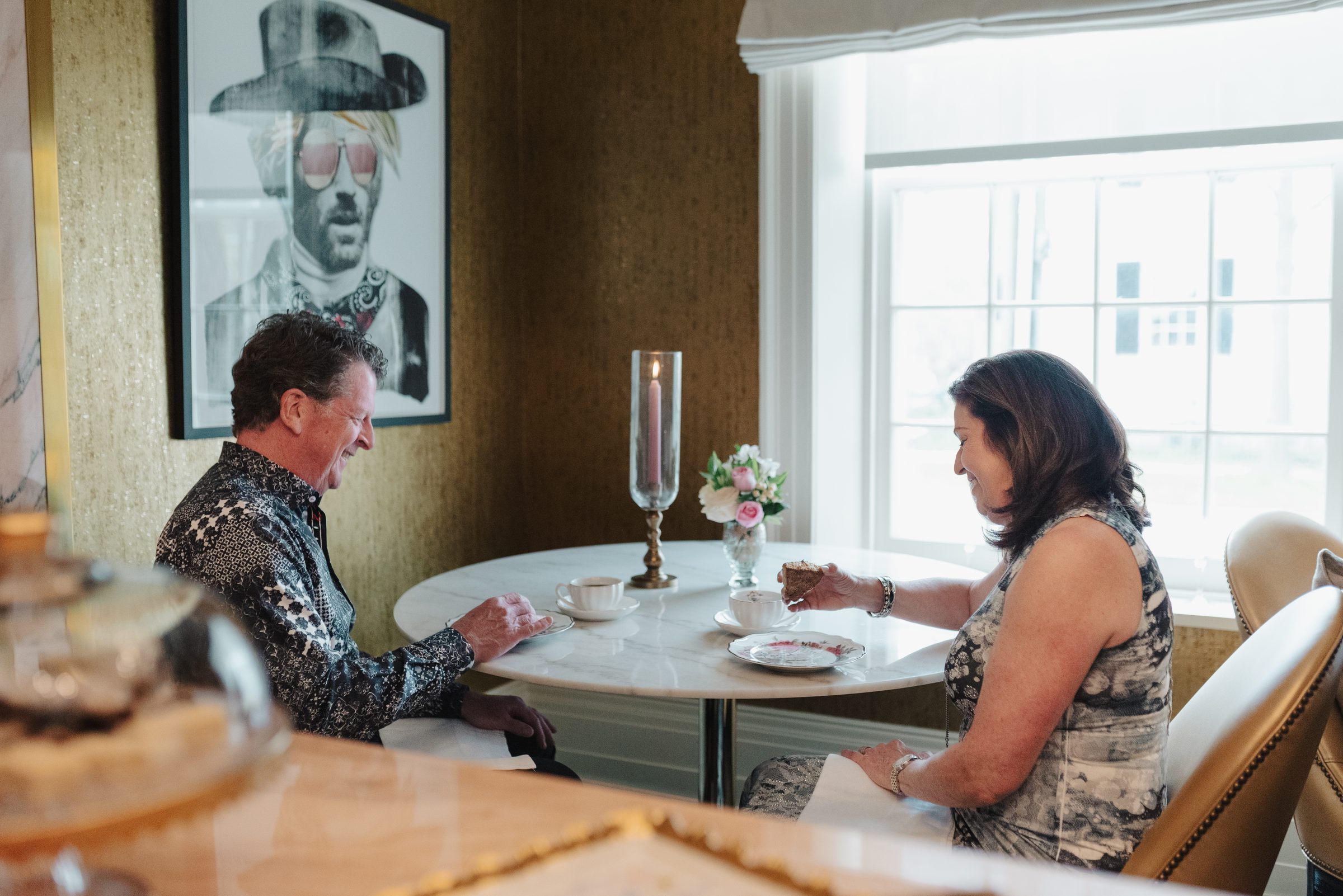 Guests enjoying tea and cake at a round marble table in a suite at The Scotsman Hotel