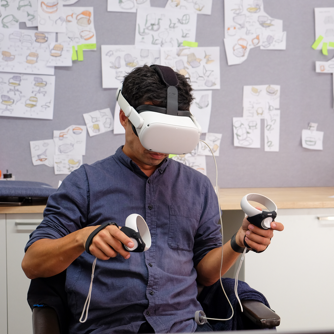 A designer wearing a VR headset and sketching in Gravity Sketch