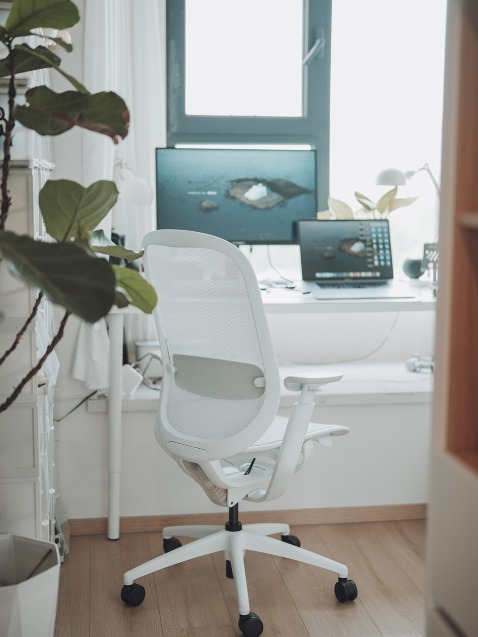 The O2 Chair by Goodtone, designed by Circ Industrial Design. A white ergonomic office chair with a mesh seat next to a white desk in a brightly lit room.
