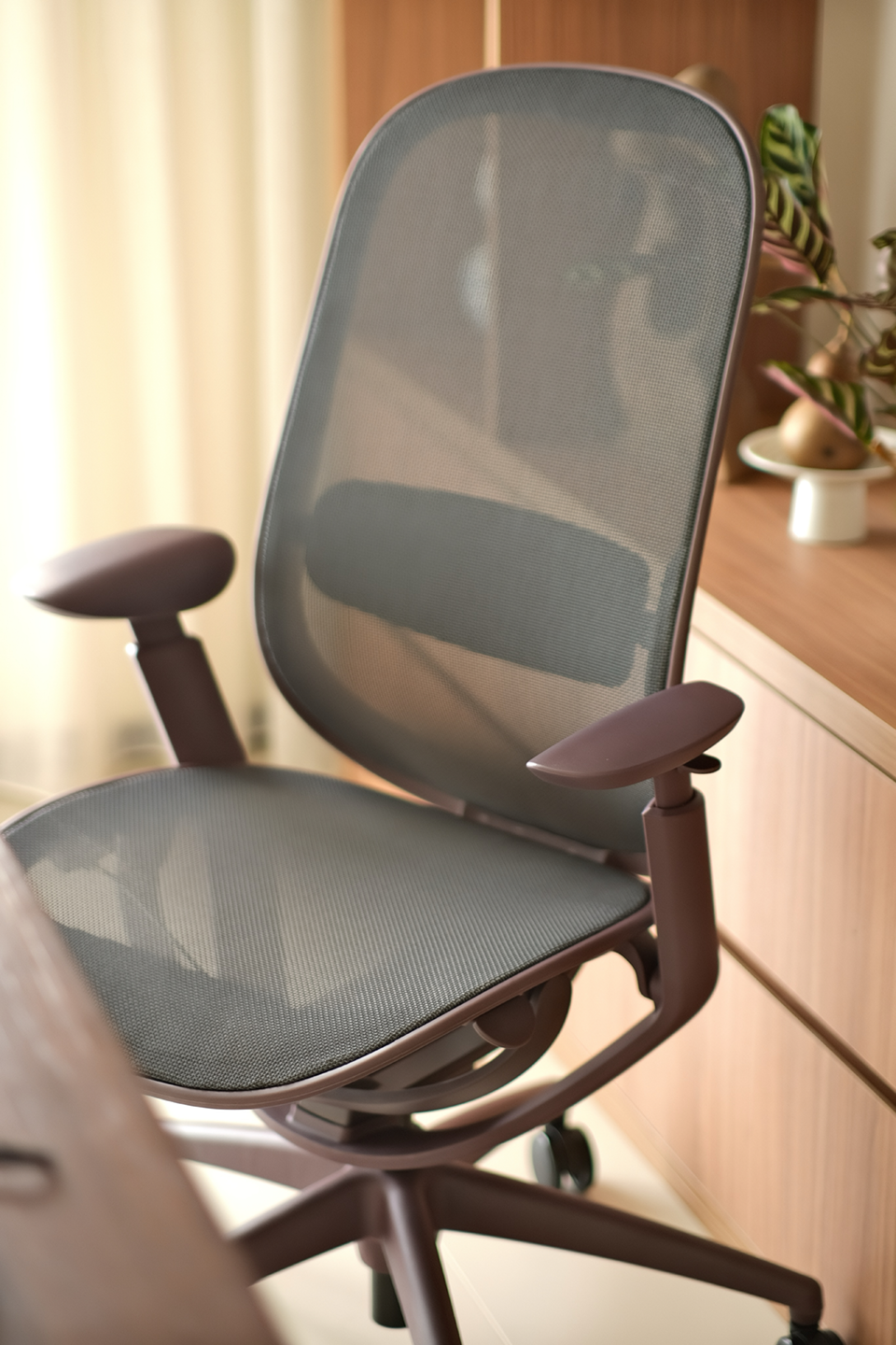 The O2 Chair by Goodtone, designed by Circ Industrial Design, shown in dark purple with a mesh seat and backrest, shown in a warm home office setting.