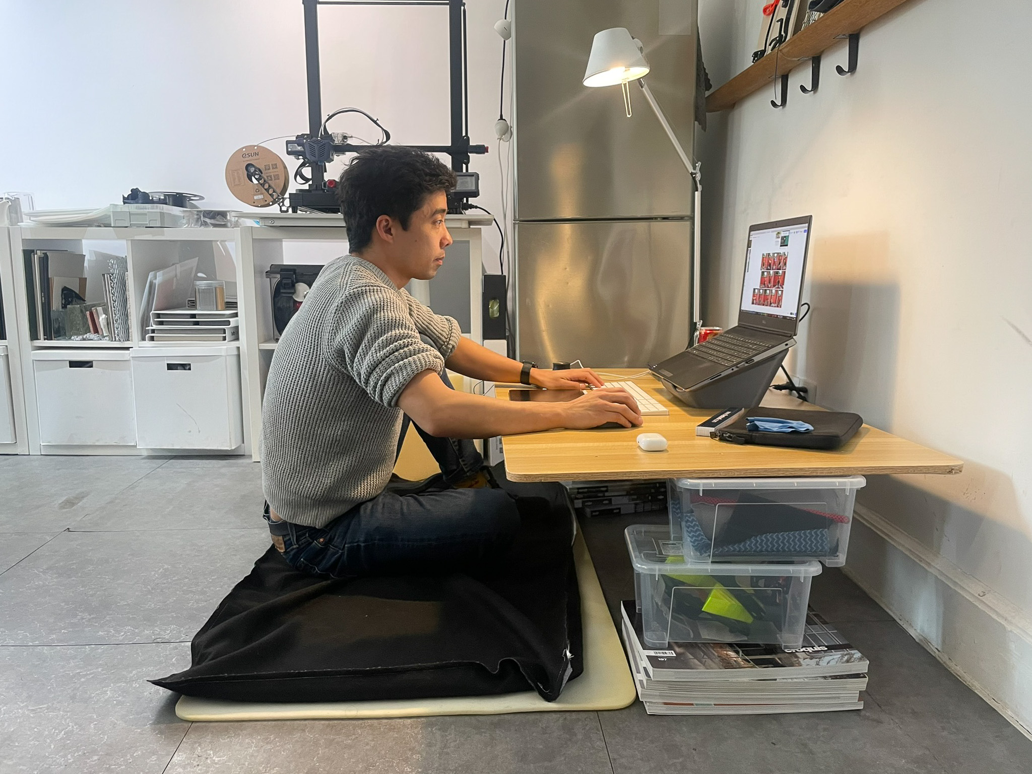 designer testing different floor working positions at a makeshift table