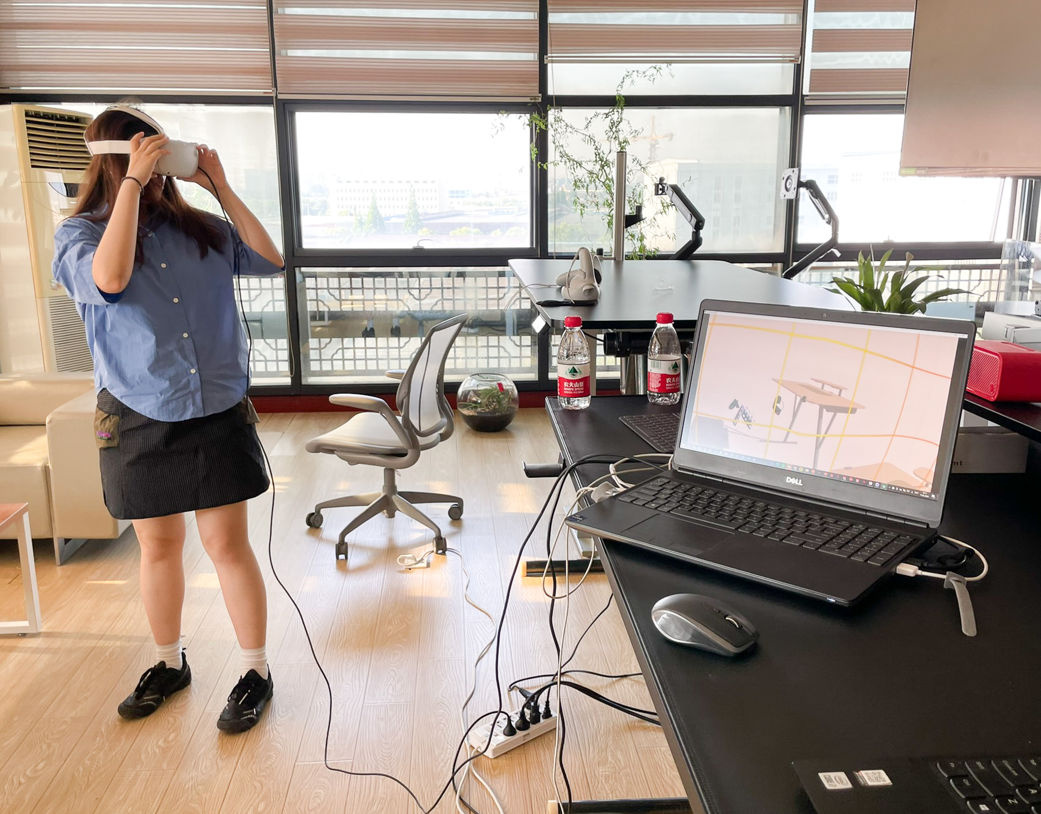 designer looking at the marinamantra flow desk in VR while standing in a cluttered office