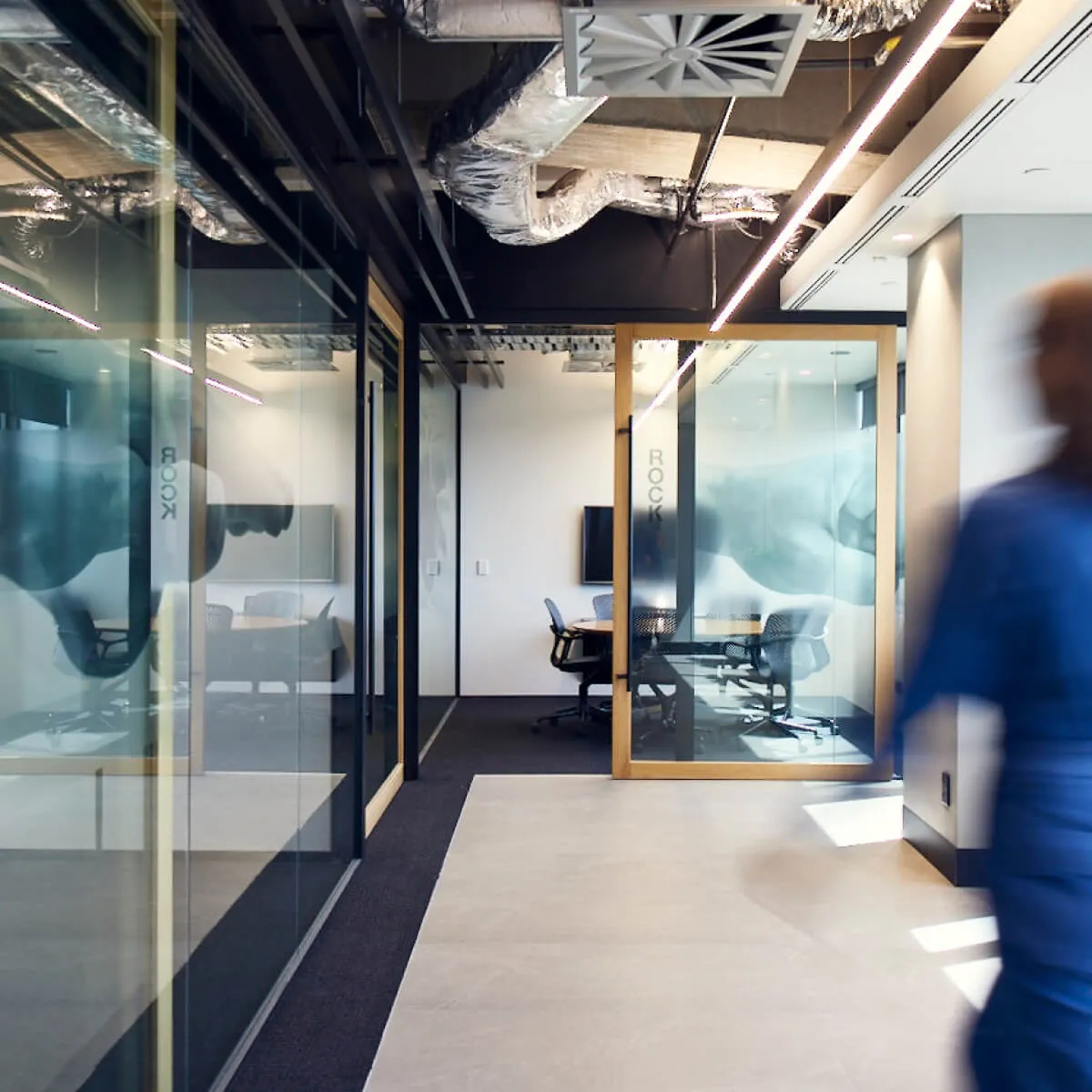 A man in a blue suit walking down the office