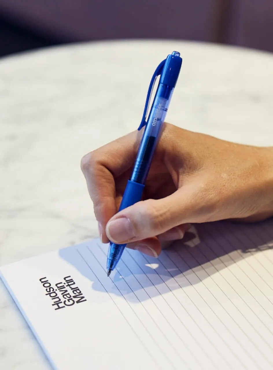 Someone writing on a notepad