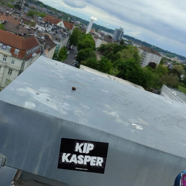 KIP KASPER Sticker auf einer Dachrinne, Blick auf Aachener Skyline.