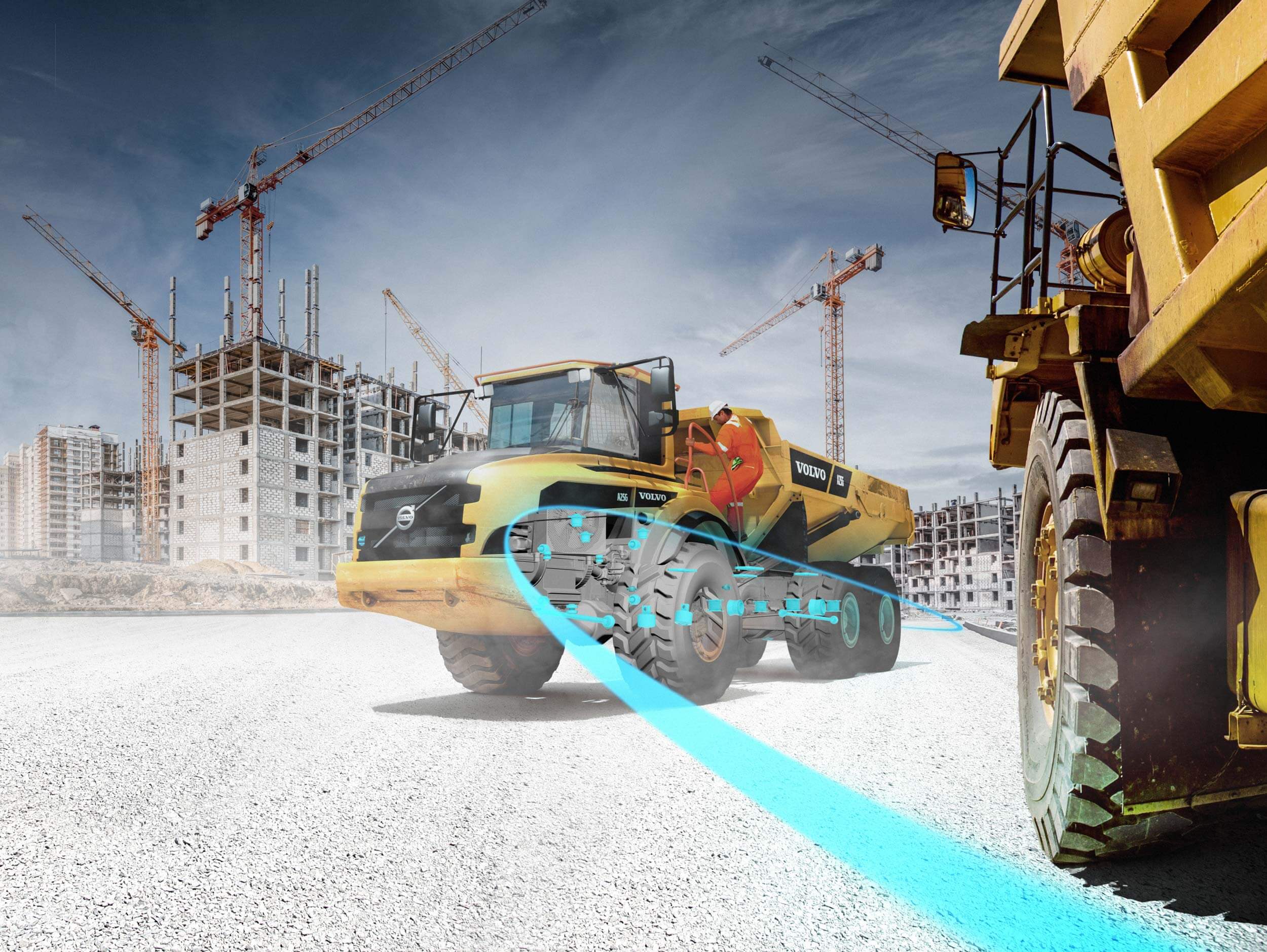 a yellow bulldozer driving down a road next to a construction site