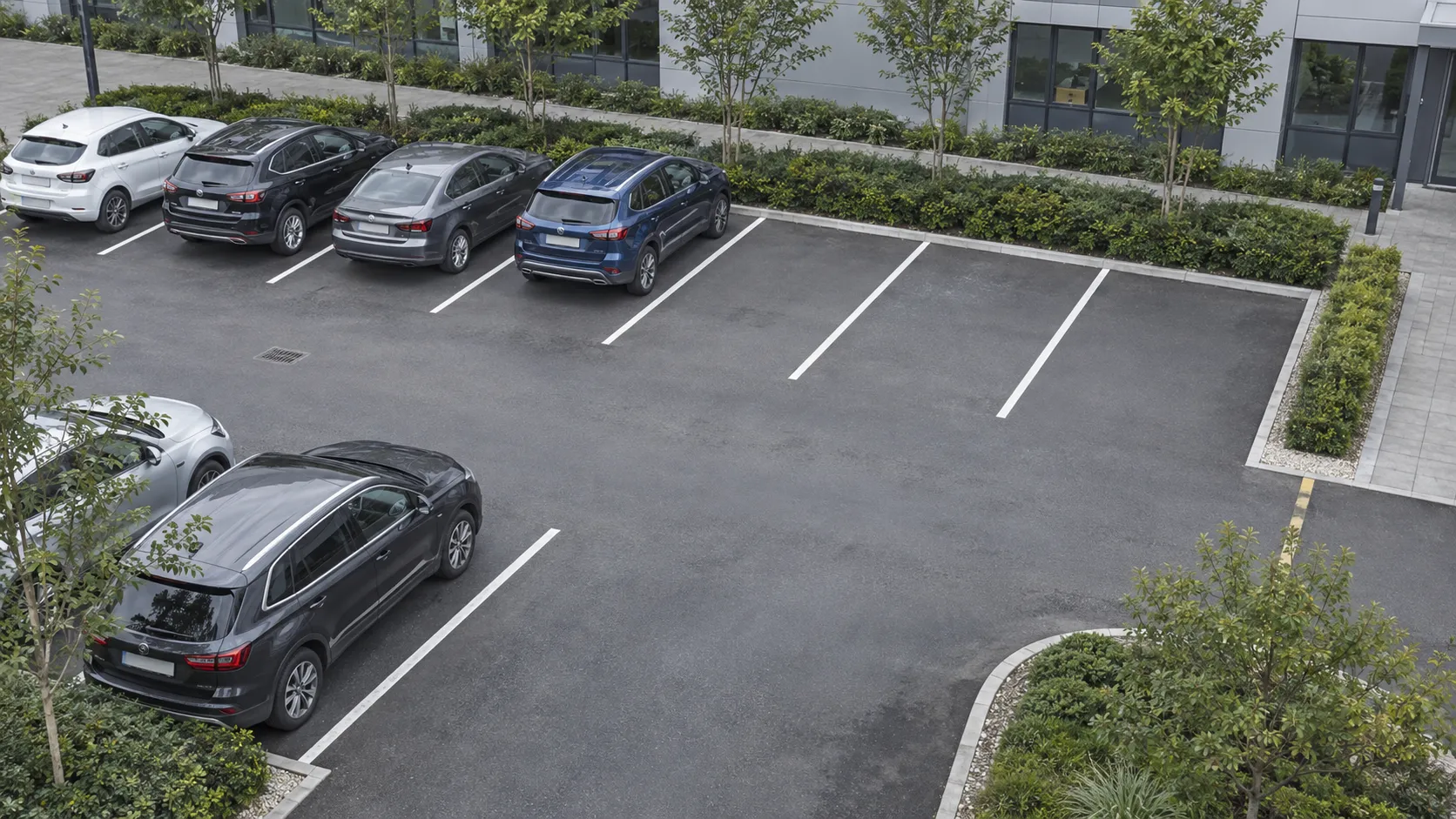 Wide security camera view of a parking area with three vacant spaces