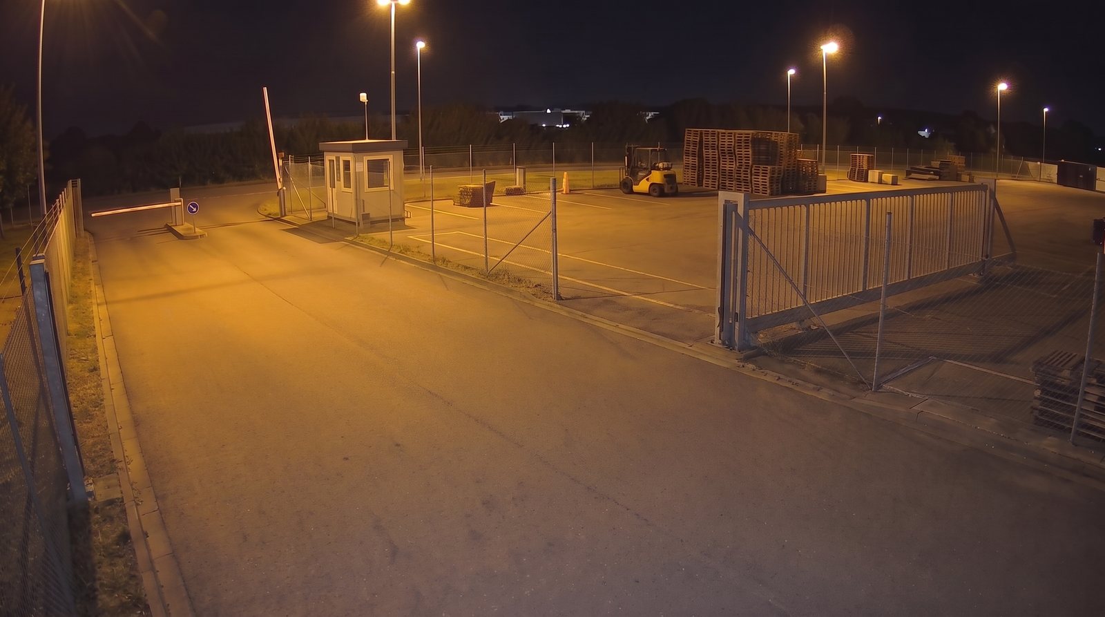 Yard gate at night, open: the road is clear and the panel is parked behind the fence