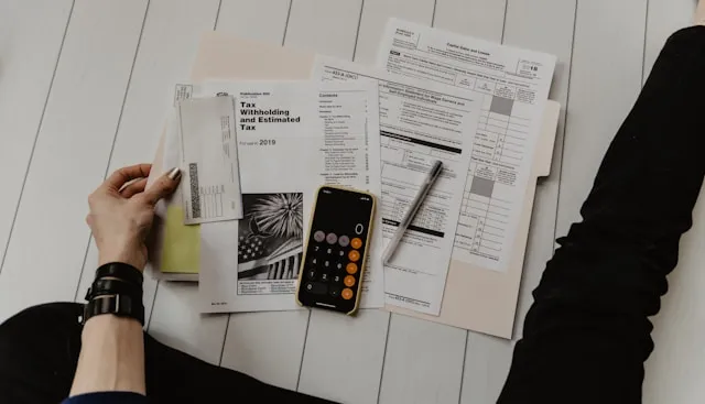 Picture of tax forms, a calculator, and a checkbook