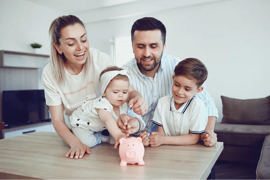 Family putting money into a piggy bank