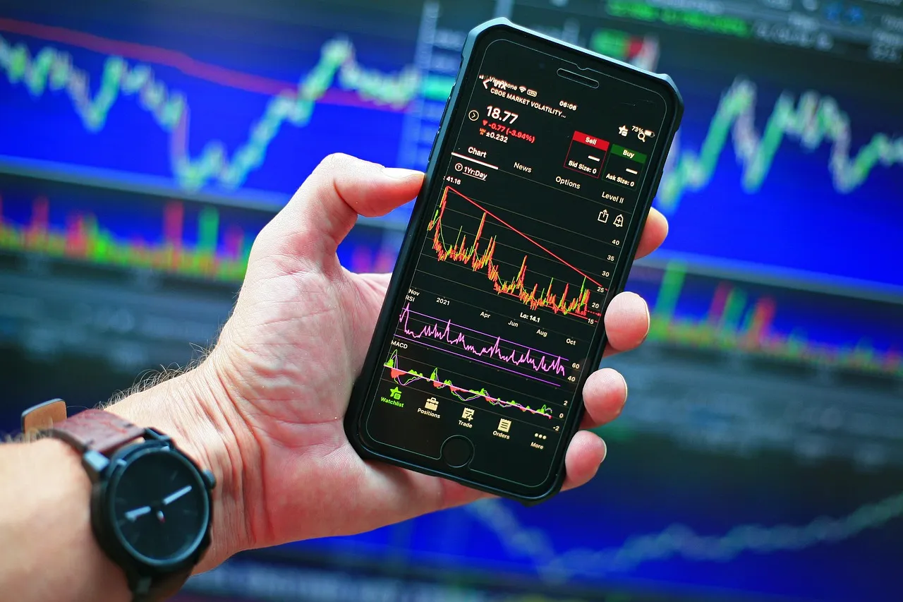 Person holding a phone with a stock chart