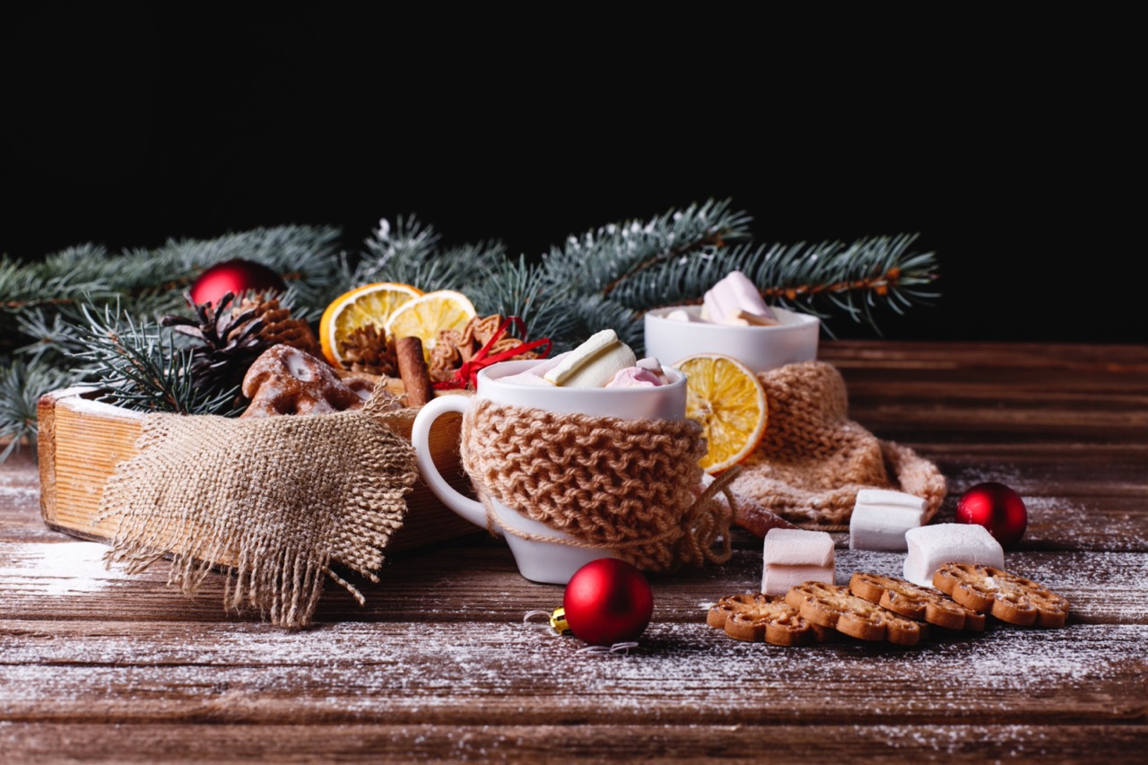 Warme mokken chocolademelk met marshmallows, kerstdecoratie en koekjes op een houten tafel – sfeervol kerstontbijt bij Campus Offices.