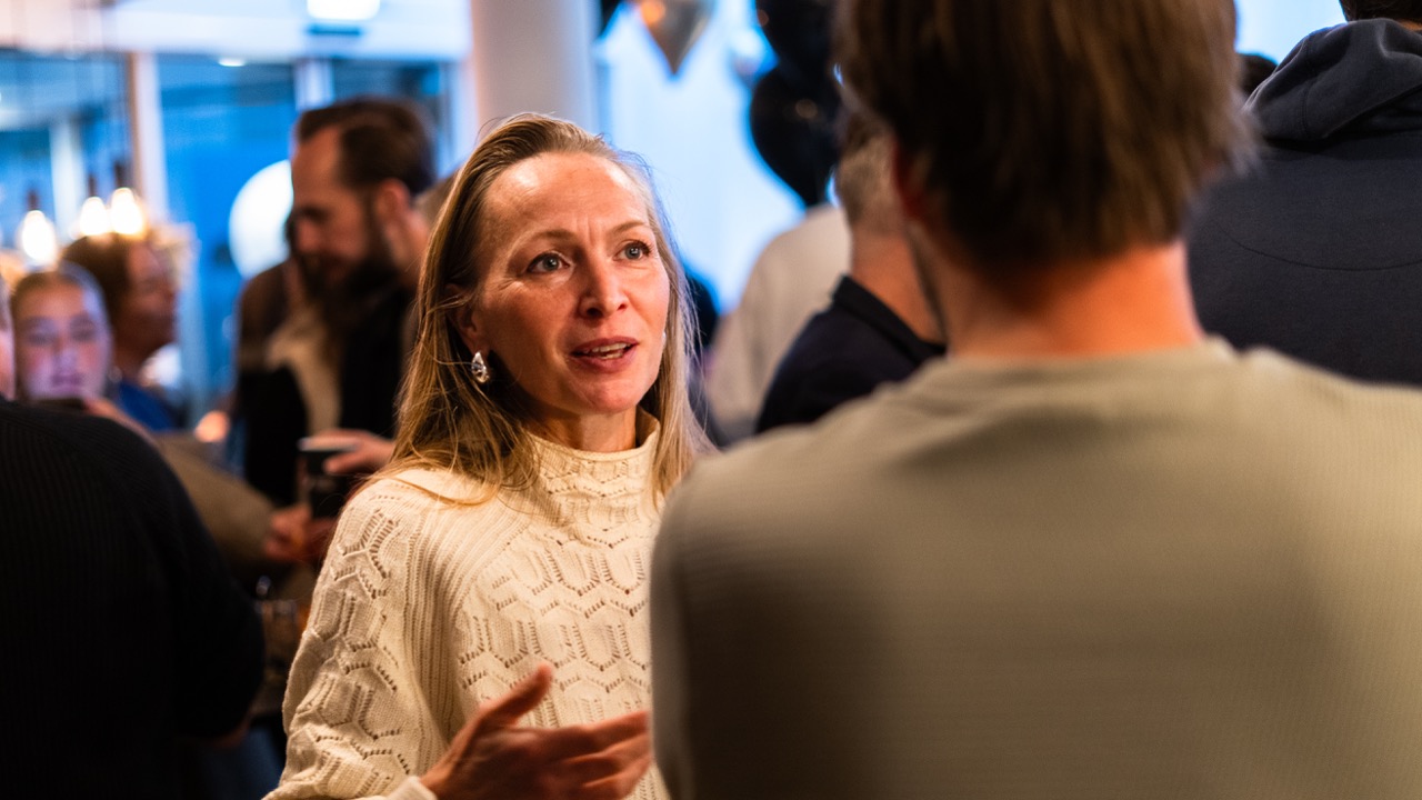Ruim ingerichte meetingroom in Almelo waarin klapbare tafels te zien zijn met een groot presentatiescherm. 