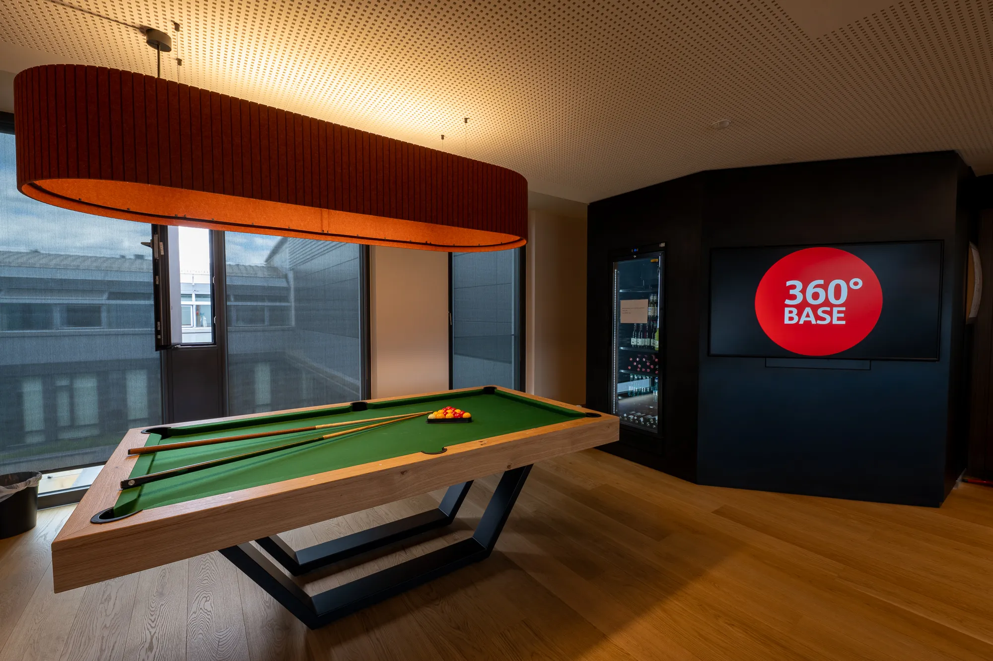 Flexibler Meetingbereich mit Billiardtisch und Bildschirm für moderne, kollaborative Arbeitsformate.