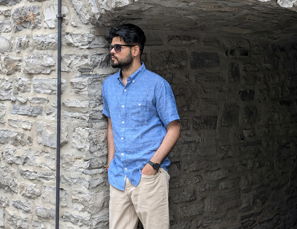 Meet Chaudhari in a casual portrait against a stone wall in Quebec City