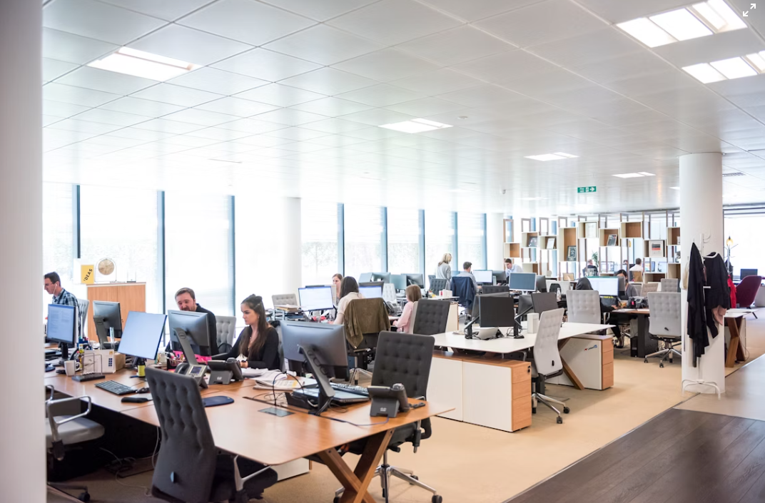 Spacious open plan office with teams working on computers