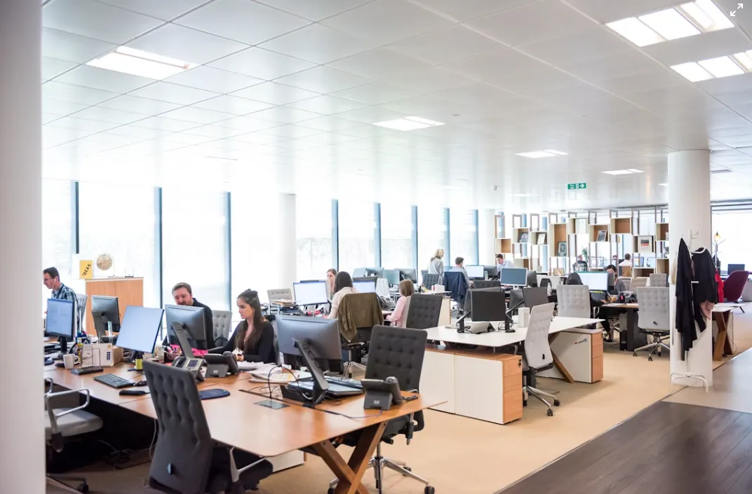 Spacious open plan office with teams working on computers