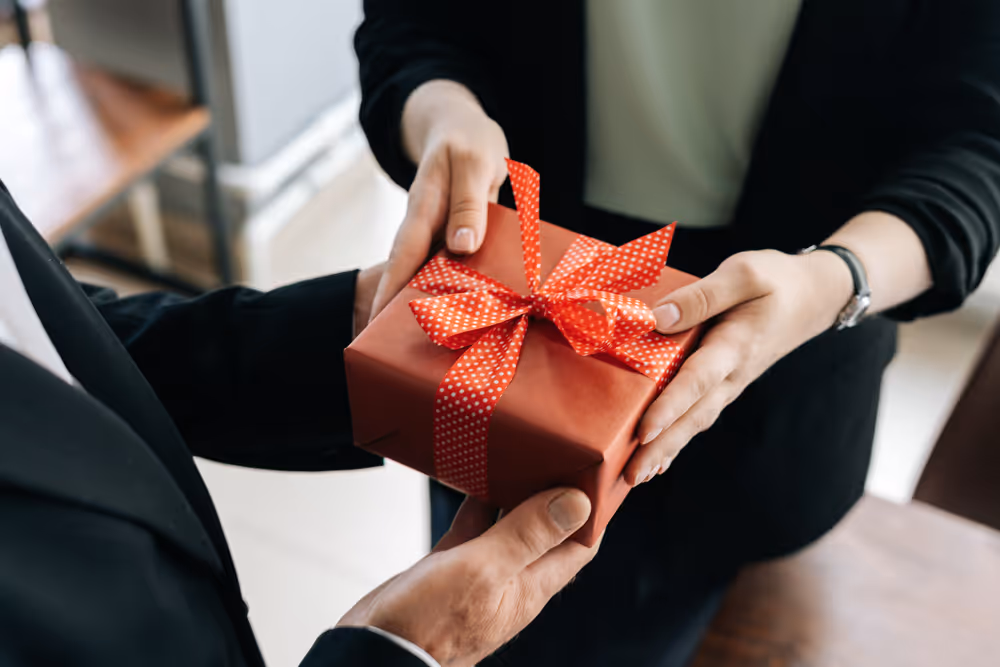 un employeur remet un cadeau à une salariée, concept d’avantages en nature