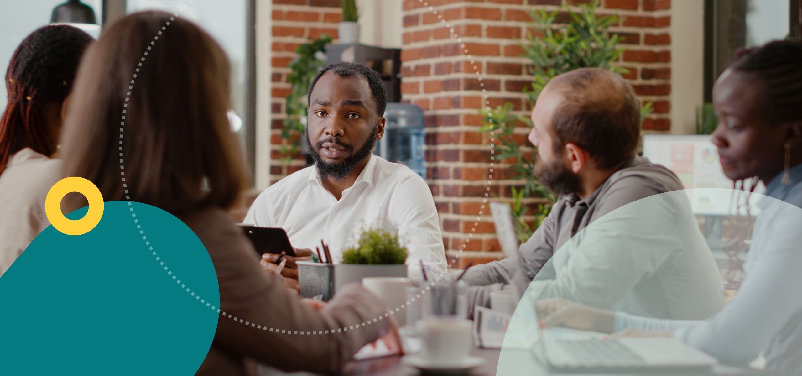 Five diverse board members having a discussion around a table