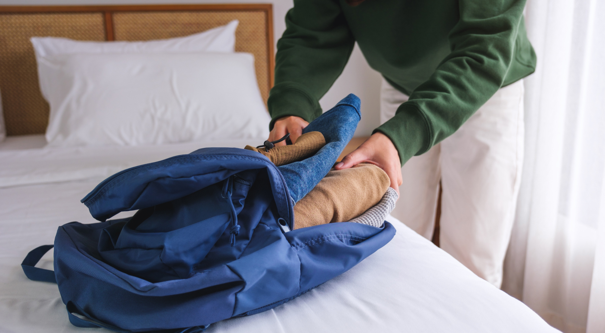 Person packing clothes into backpack