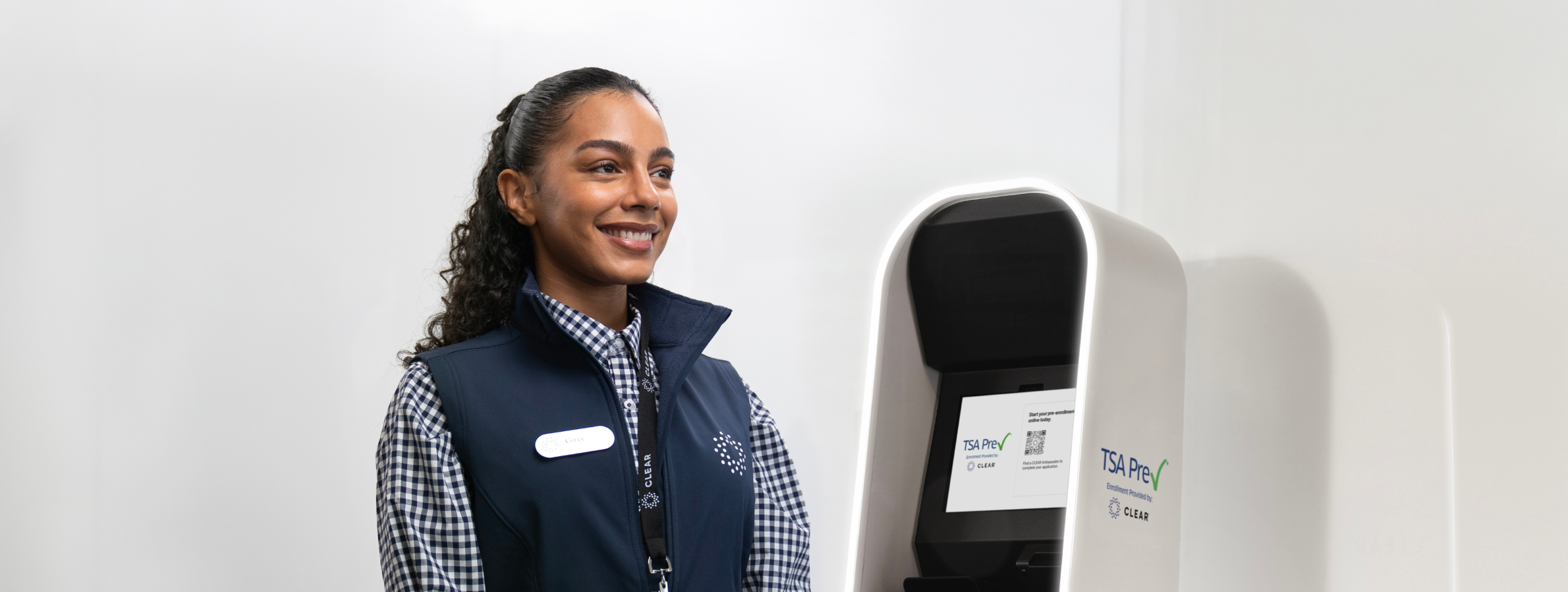 CLEAR Ambassador standing in front of TSA PreCheck® Enrollment Pod