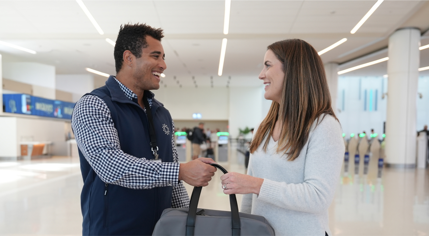 CLEAR Ambassador helping customer with bag
