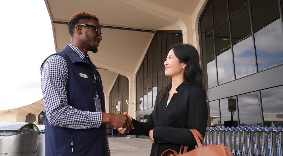 Photo of a CLEAR Ambassador shaking hands with a traveler