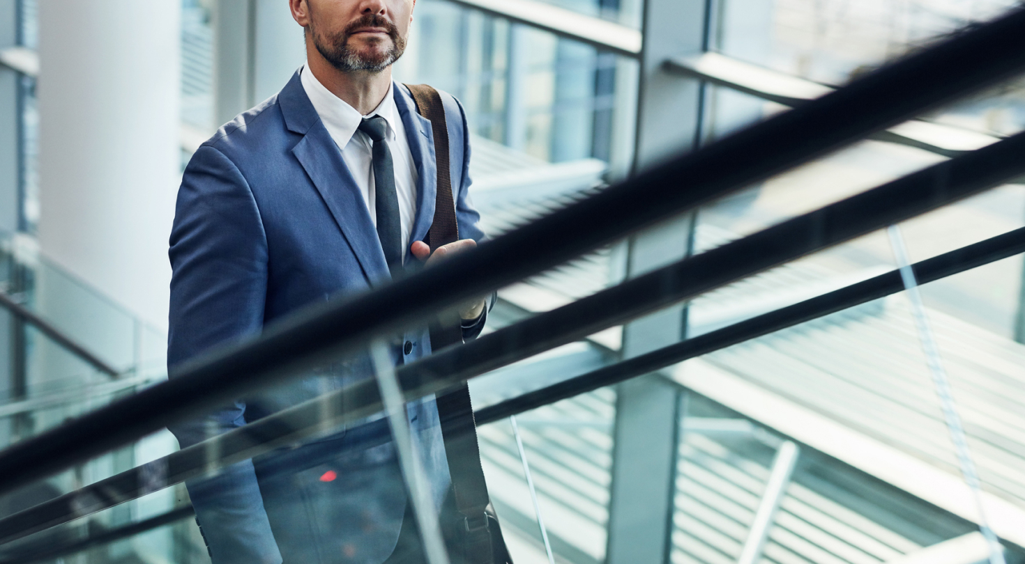 Image of a business man going up the escalator