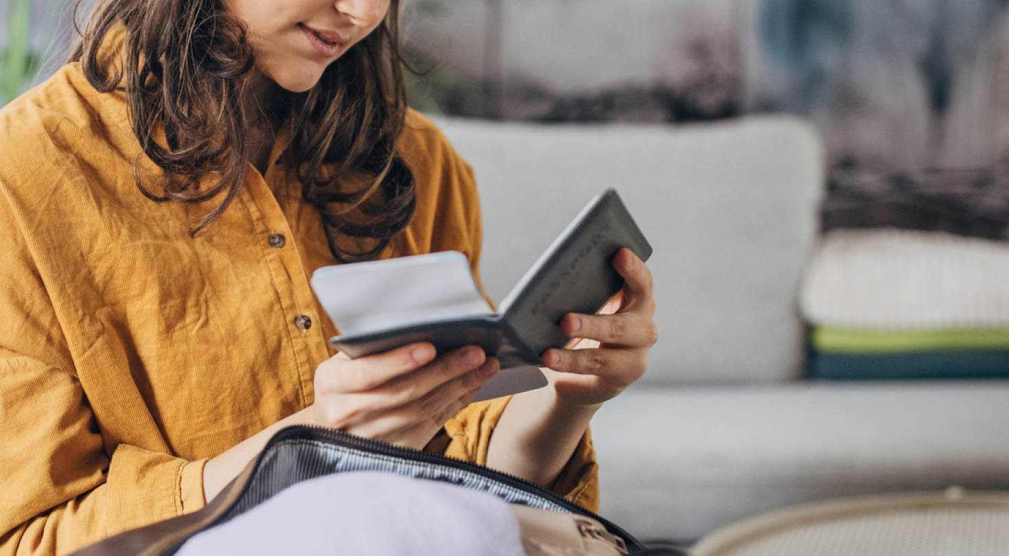 Person looking at their passport and ticket in their living room