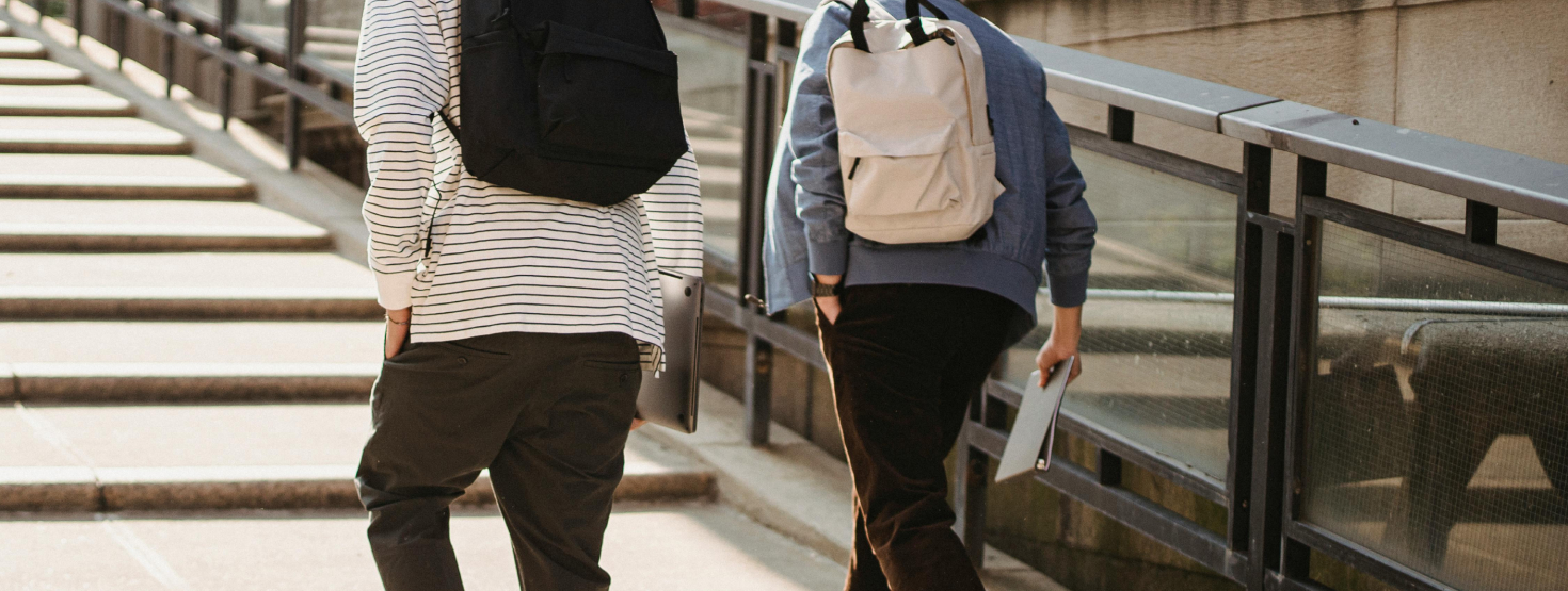 College students with backpacks walking up stairs in quad