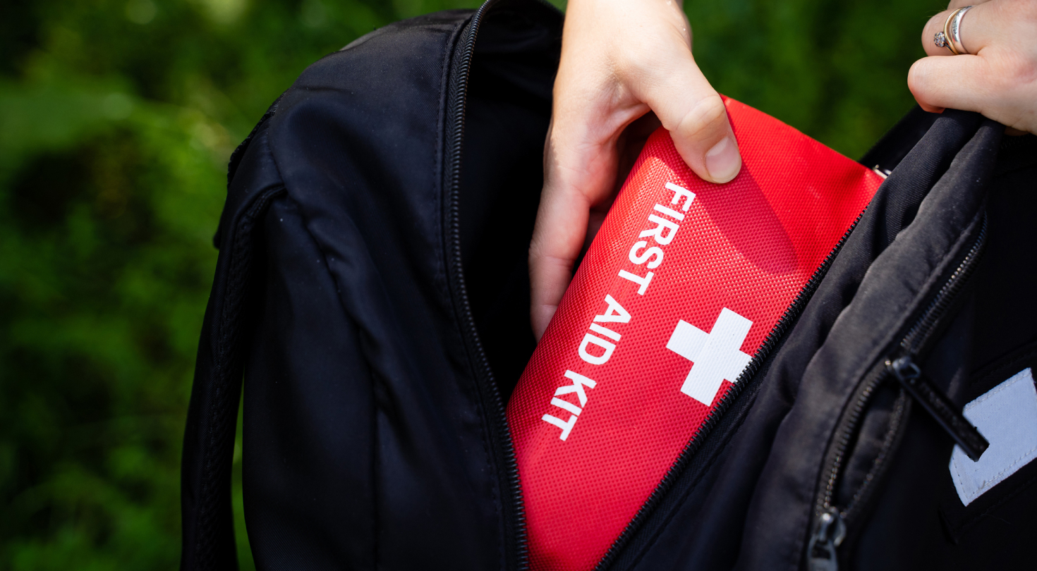 Photo of person taking a first aid kit out of backpack