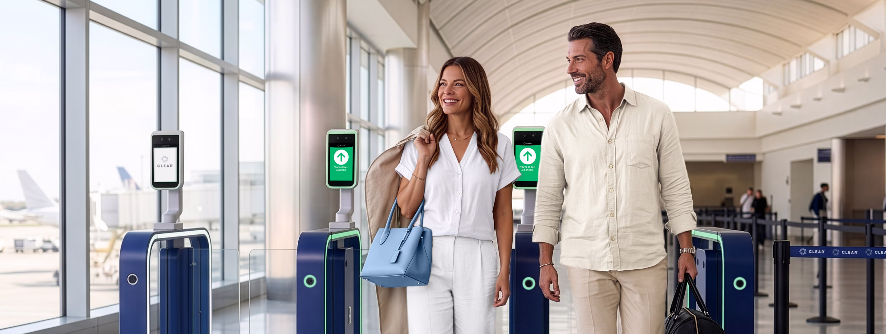 Image of Couple walking through eGate with the wife carrying a wedding dress garment bag over her shoulder.