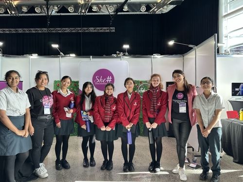 She Sharp ambassadors with a group of students smiling at the camera at the Tomorrow Expo event