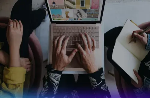 3 people are viewing a laptop screen that displays images in tiles