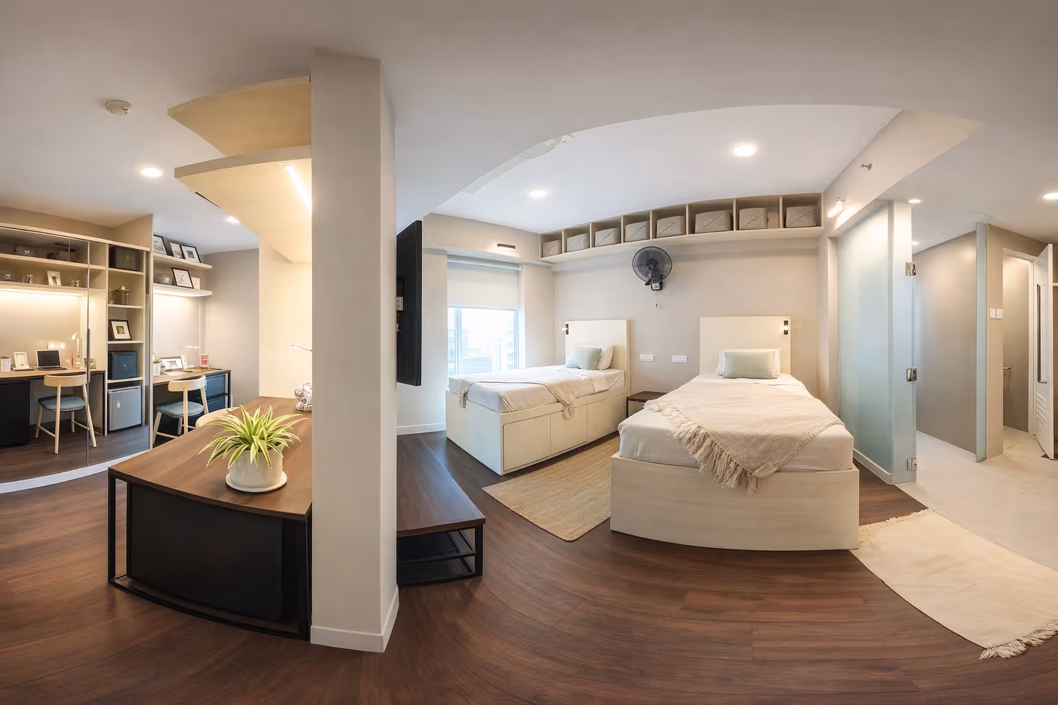 Modern twin bedroom with two single beds, wall-mounted fan, built-in shelves, and an adjacent study area with desks and chairs.