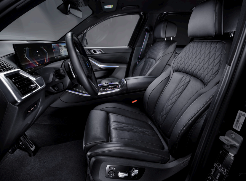 Luxury car interior featuring a checkered leather bag, SOHO VIP Chauffeurs brochures, a wrapped chocolate, and a business newspaper on the passenger seat.