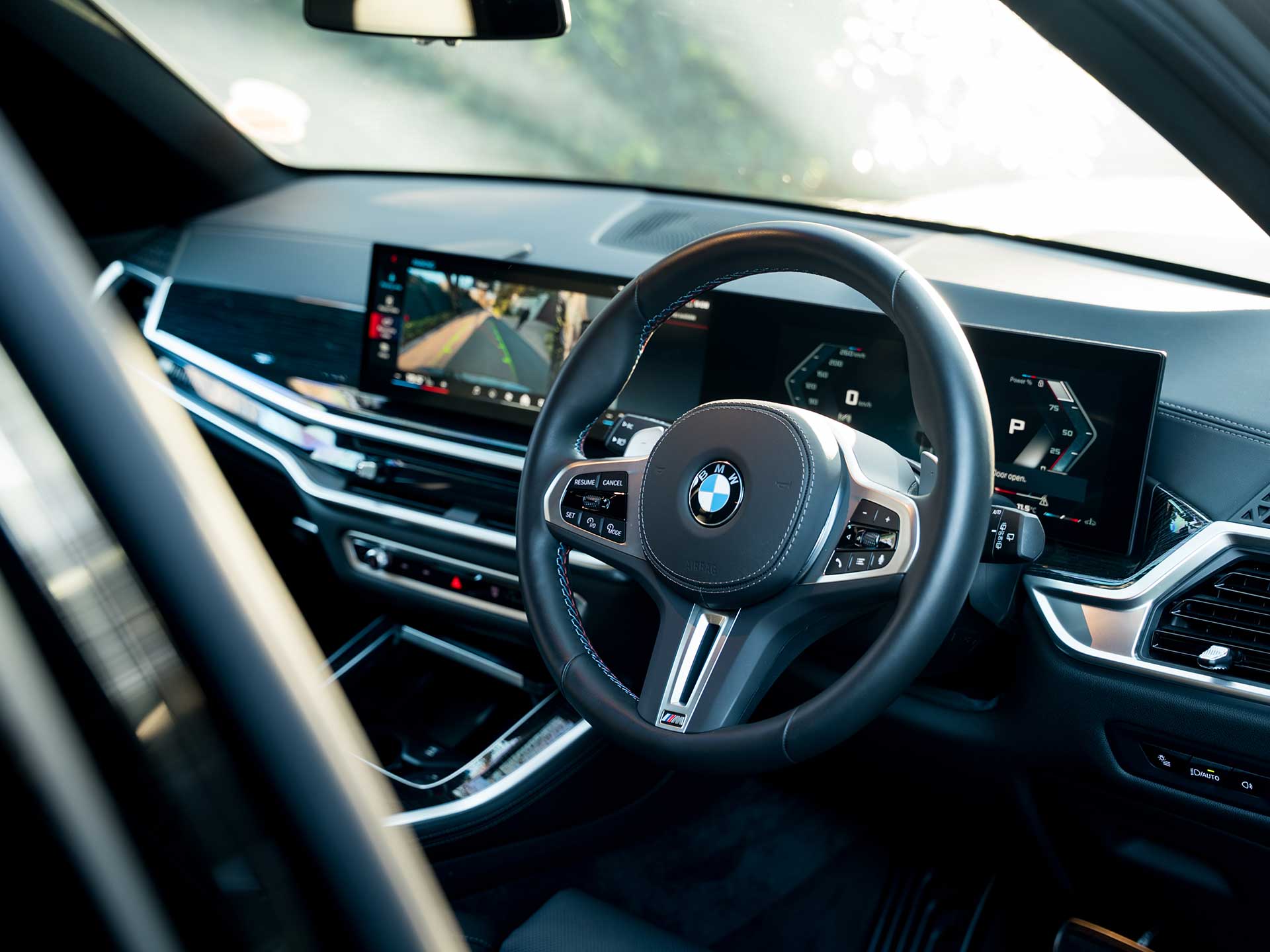 Luxury car interior featuring a checkered leather bag, SOHO VIP Chauffeurs brochures, a wrapped chocolate, and a business newspaper on the passenger seat.