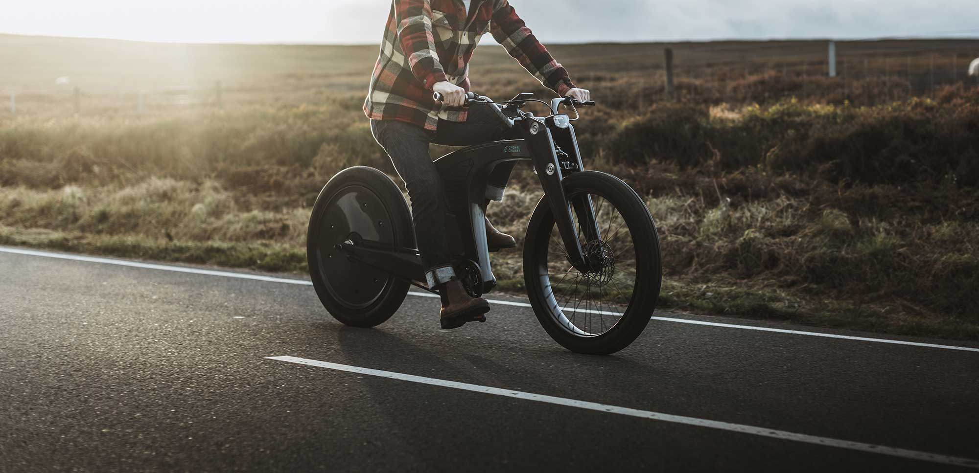 Man riding his Crown Cruiser e-bike at speed through winding country roads