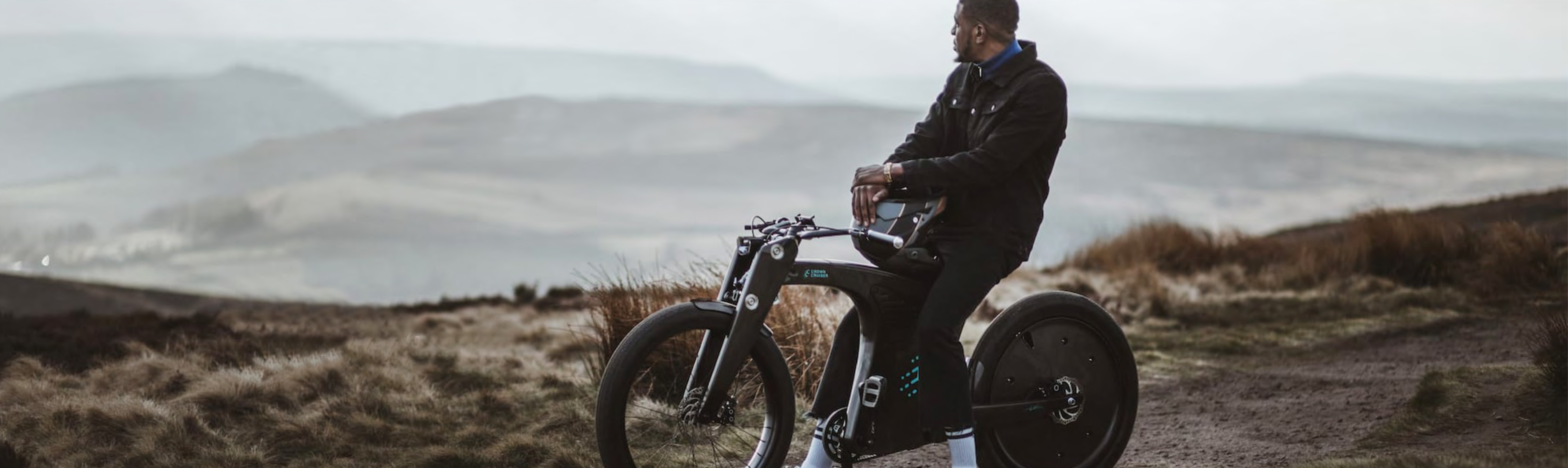 Young man stopping to enjoy the hilly views while off roading his Crown Cruiser E-bike