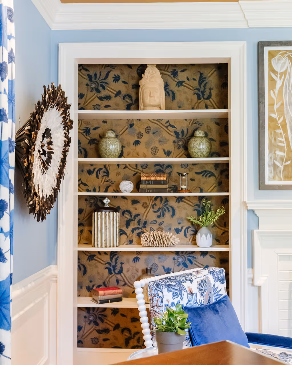 Wallpapered bookcase with feathered headdress