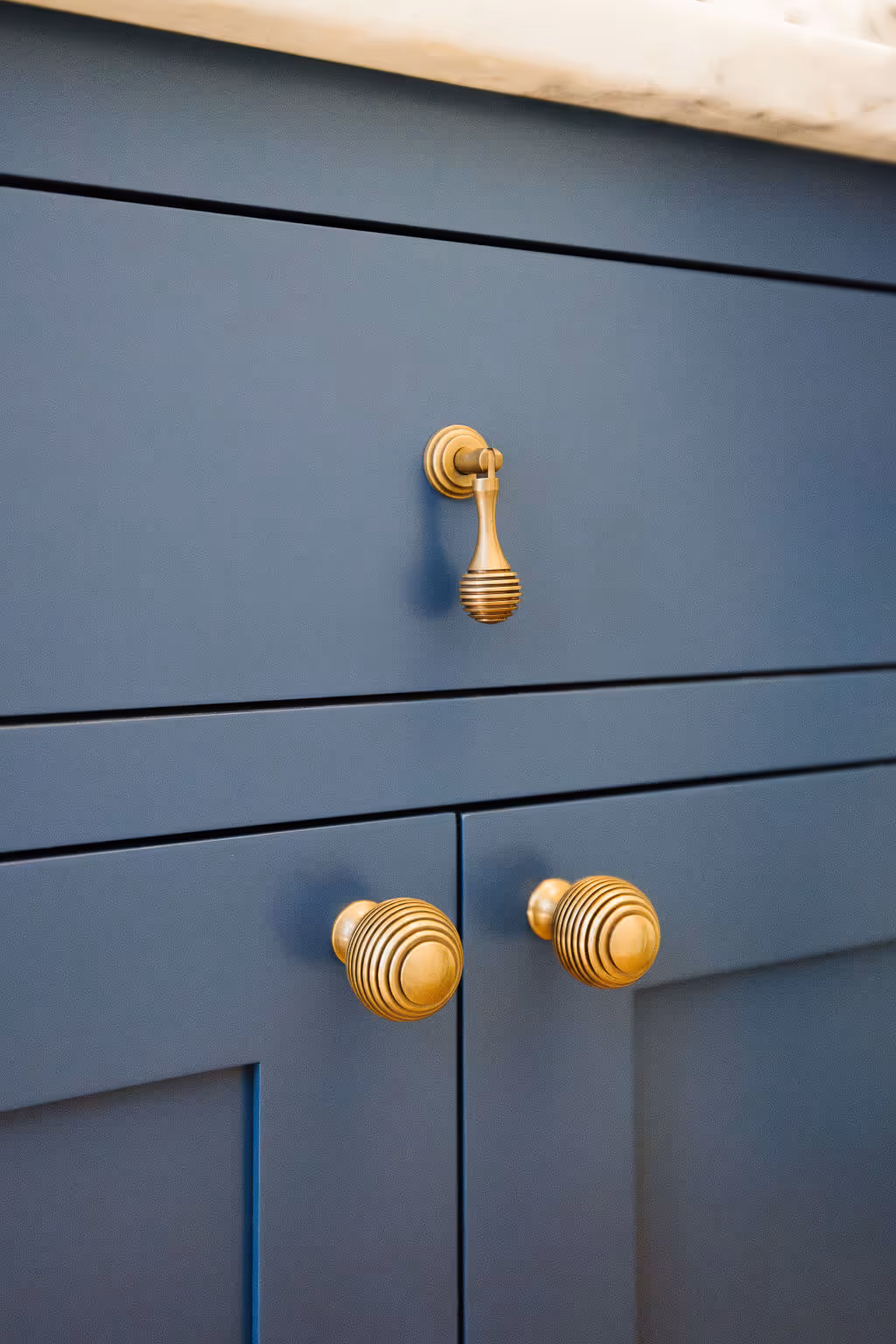 Decorative hardware on blue cabinets