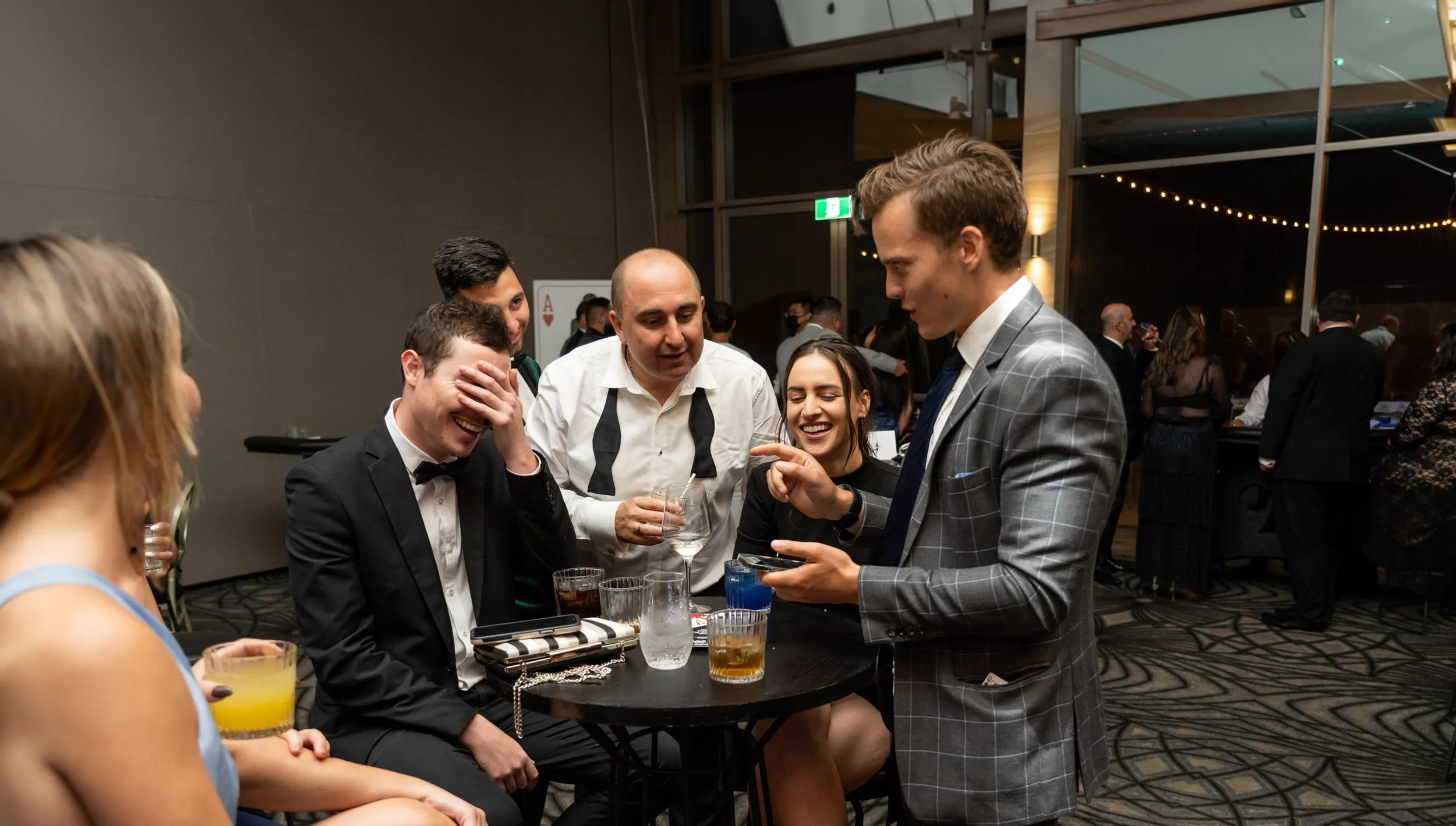 Mike performing close up magic to a small group at a party 