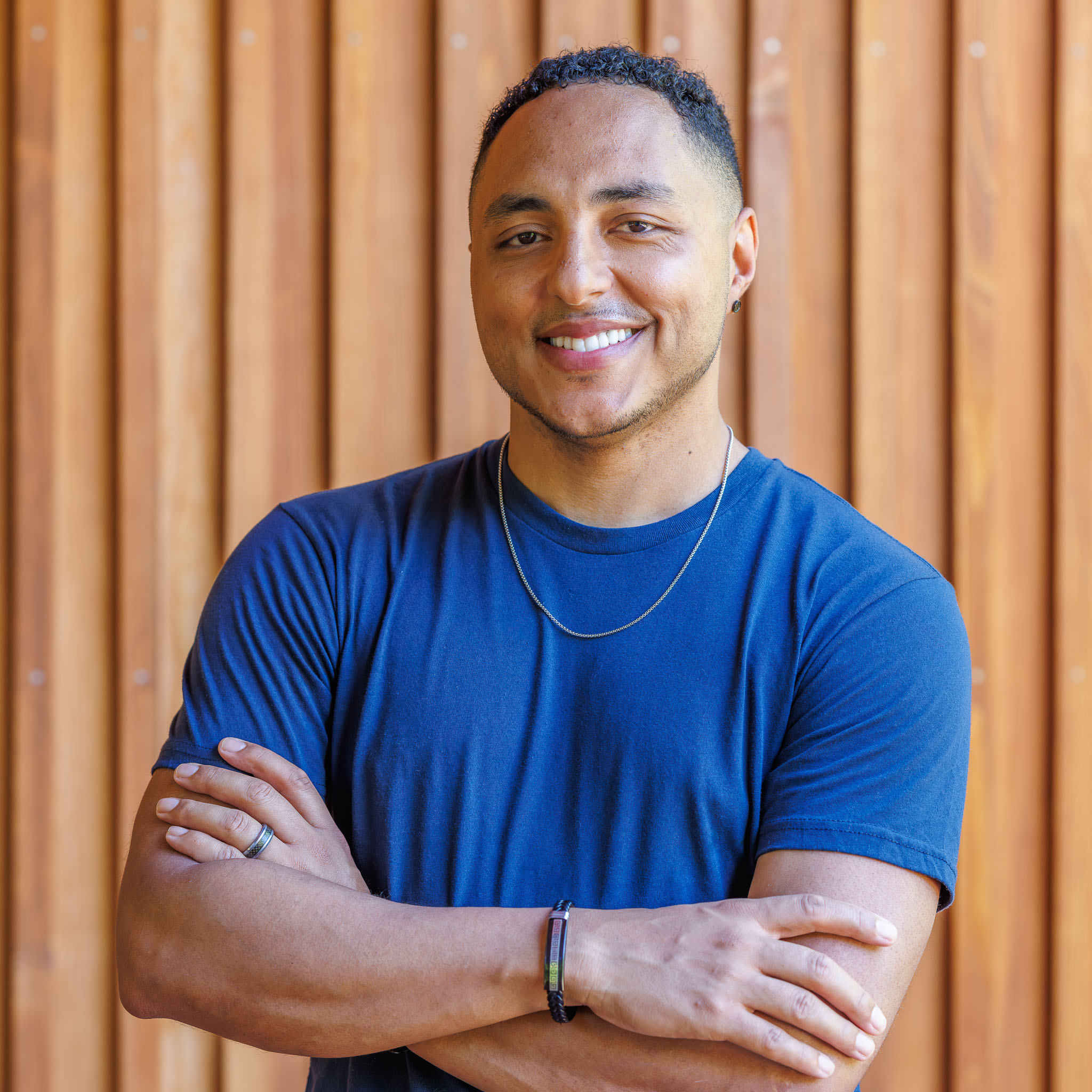 Male with blue T-Shirt crossed arms smiling photography
